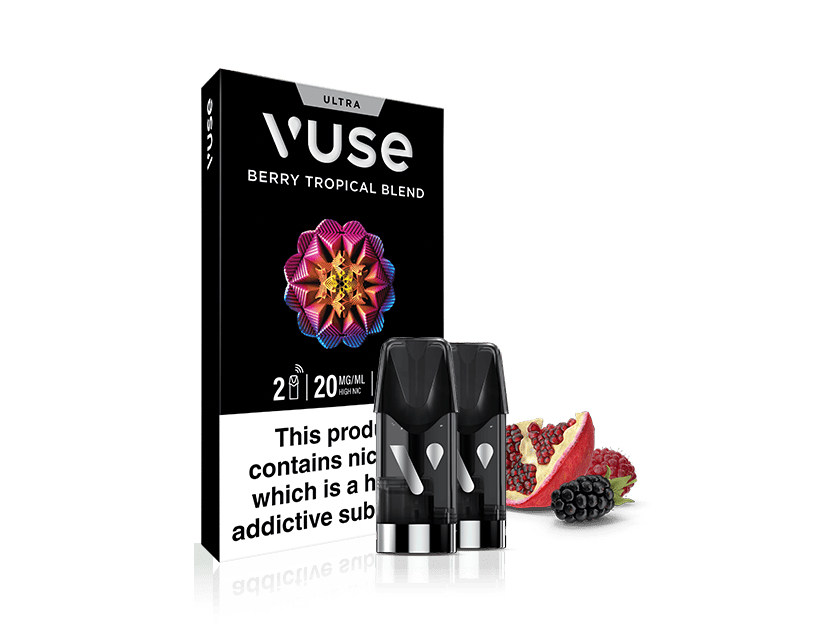 A Vuse Berry Tropical Blend vape pod pack with two pods in front. Beside them are a pomegranate half and blackberries. The packaging warns: This product contains nicotine which is a highly addictive substance.