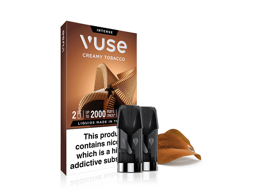 A box of Vuse Intense Creamy Tobacco vape pods is shown with two pods in front and a brown tobacco leaf beside them. The box highlights 2 pods per pack and a nicotine warning label at the bottom.