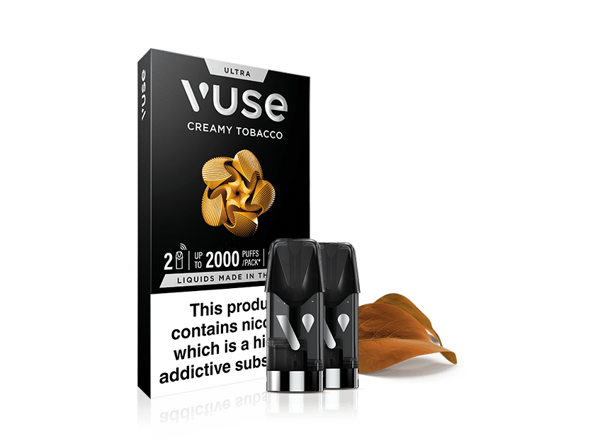 A box of Vuse Ultra Creamy Tobacco e-liquid pods, labeled 2 pods, up to 2000 puffs per pack. Two black vape pods and a brown tobacco leaf are shown beside the box. Warning: contains nicotine.