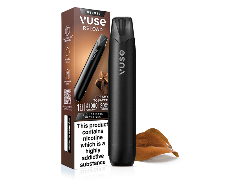 A black Vuse Reload vape pen stands next to its brown box labeled Creamy Tobacco. A tobacco leaf lies beside them. The box displays a nicotine warning and product details.