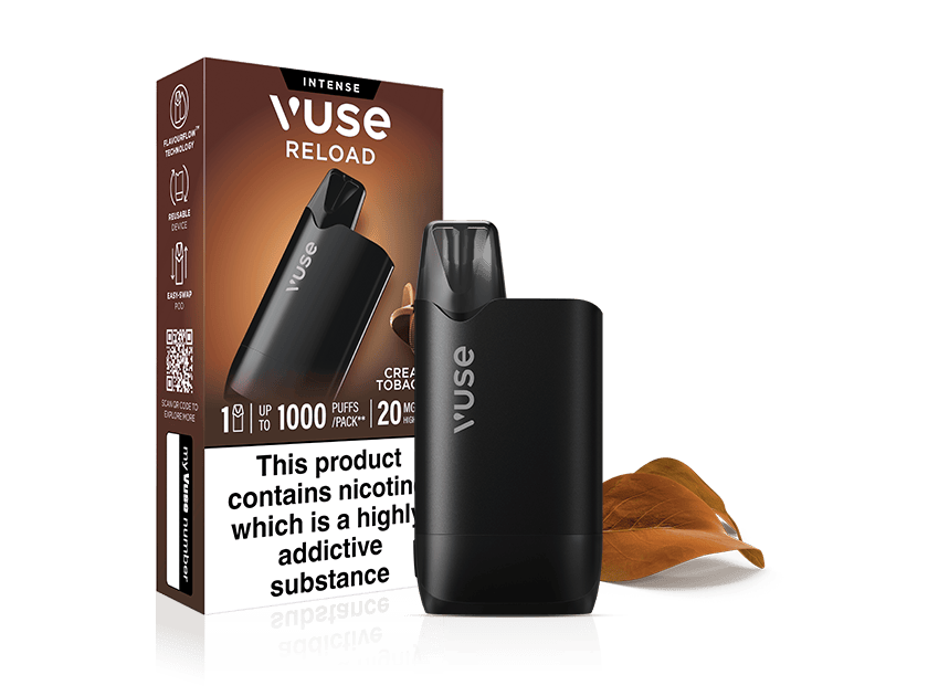 A black Vuse Reload reusable vape and its matching Creamy Tobacco Vuse Reload Box with a nicotine warning label, set against a white background with two dried leaves.