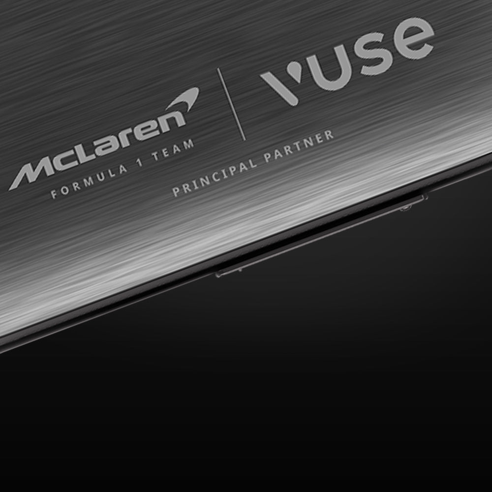 Close-up of a metallic surface featuring the McLaren Formula 1 Team logo and the Vuse logo, labeled as Principal Partner, with a sleek, modern design.