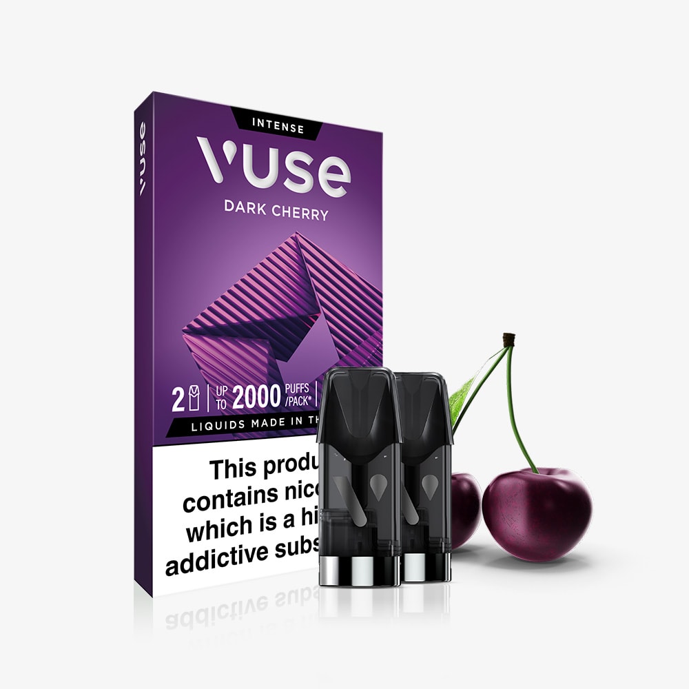 A box of Dark Cherry Vuse Extra Intense Flavour Pods stands upright next to two pods and fresh cherries, showcasing the pre-filled e-liquid and a clear nicotine warning label on the packaging.