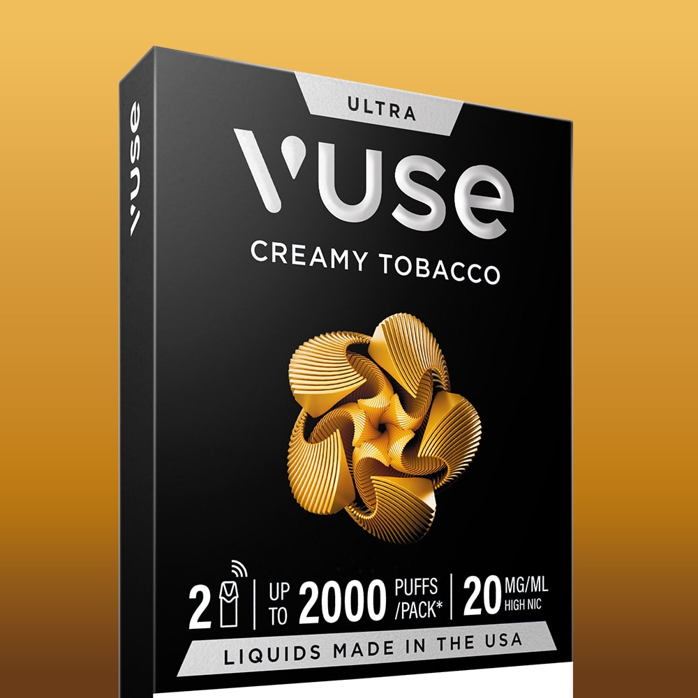 The Creamy Tobacco Ultra Smart Pod comes in a black box with gold and white accents, a gold abstract design, "up to 2000 puffs," 20 mg/ml high nicotine, and features premium USA-made liquids for an elevated vaping experience.