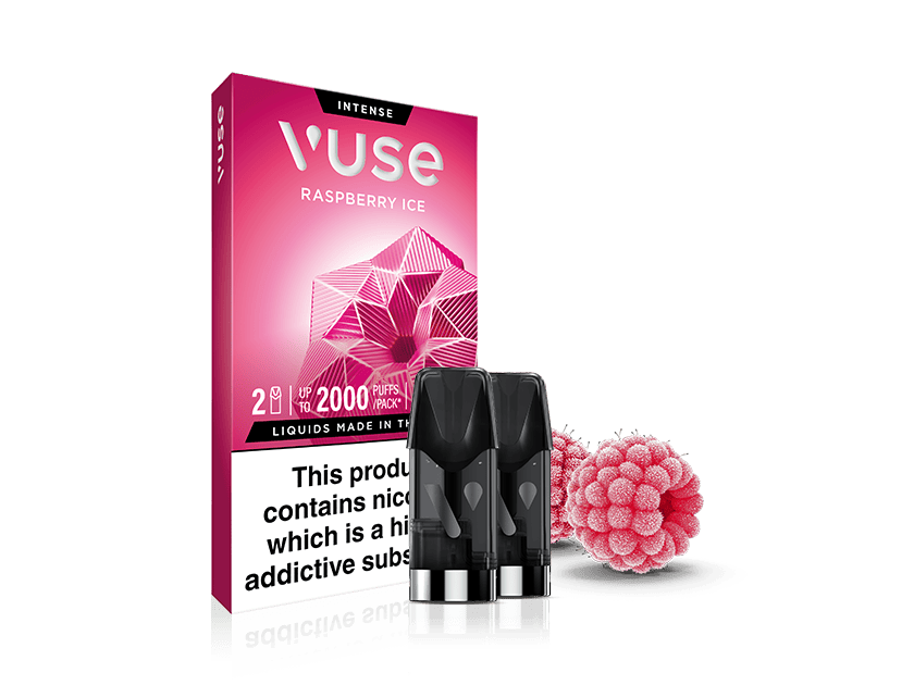 A pink Vuse Raspberry Ice vape pod pack is shown with two black vape pods in front and raspberry candies beside it. The packaging features geometric raspberry artwork and a nicotine warning label.